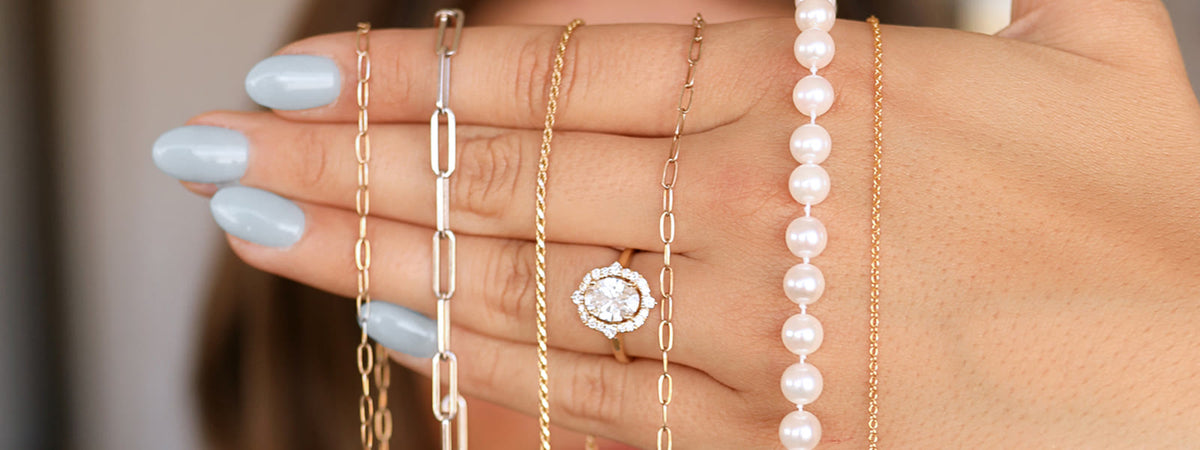 Gold chains and pearls held in a hand