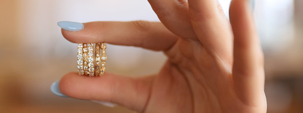 Women's diamond bands stacked in a hand