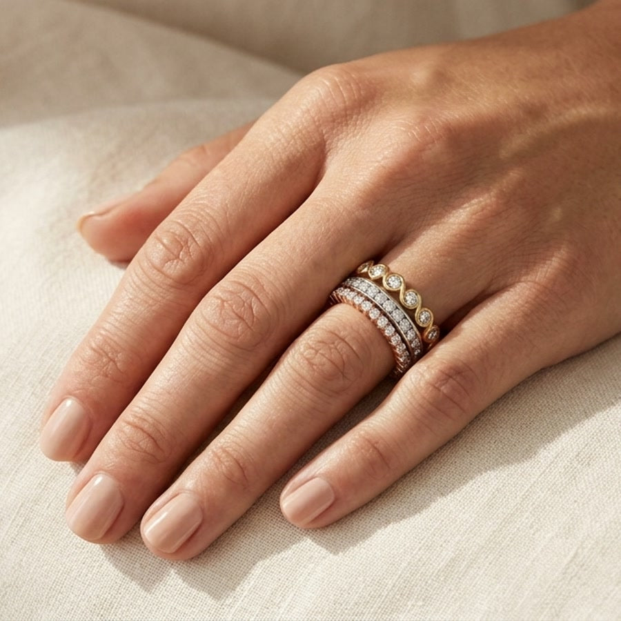 A stack of diamond wedding bands on a hand